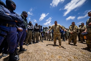 A New York Army National Guardsman provides a safety brief to service members and police officers from multiple nations.