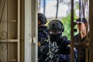 Police enter a room with guns during close quarters combat training.