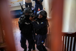 Police scans for potential threats while moving to the second floor of their objective during close quarters combat training.