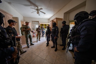 Interagency training specialist, Rick Clements, provides feedback to members of the Barbados Police Service Tactical Response Unit after their initial raid and clearing during close quarters combat training.