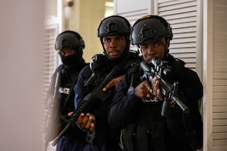 Barbados Police Service Constable Javon Ifill, Sgt. Andra Miller, and Constable Ricardo Hunte, assigned to the Tactical Response Unit, enter and clear a room of their objective during close quarters combat training.