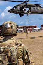 A U.S. Coast Guard tactical operator with Maritime Security Response Team East fast ropes from a U.S. Army UH-60M Black Hawk helicopter during exercise TRADEWINDS 24 (TW24) at Paragon Army Base, Barbados, May 13, 2024.