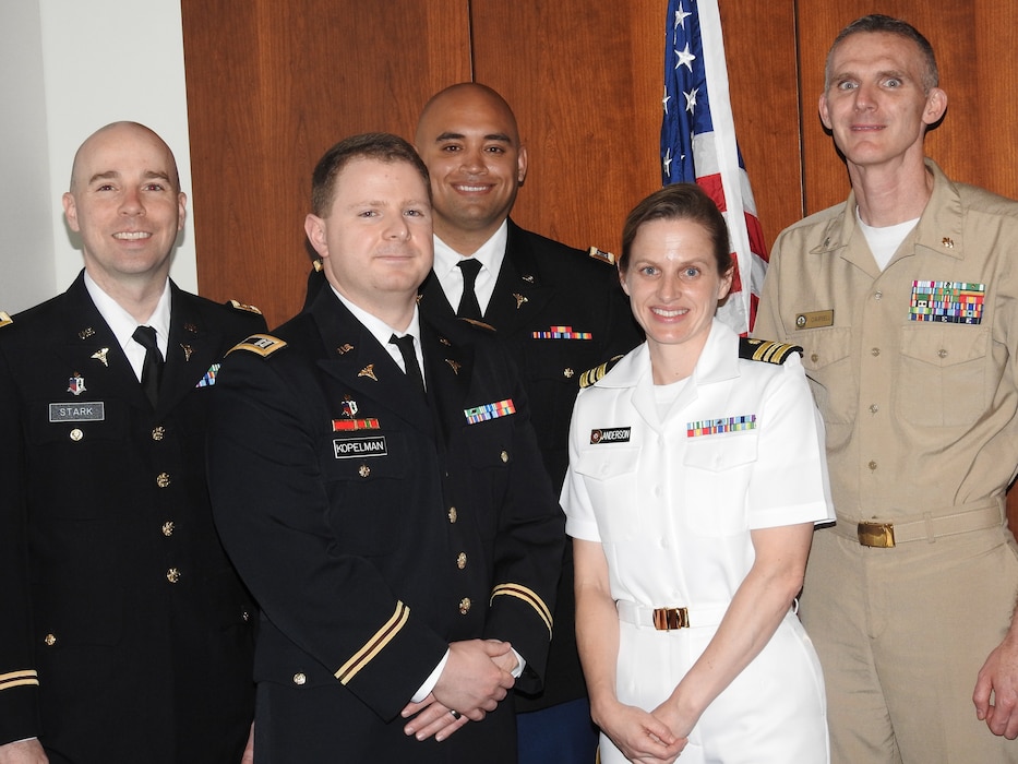 U.S. Navy Cmdr. (Dr.) Wesley Campbell (right), director of education, training and research at Walter Reed National Military Medical Center, congratulates presenters for the Robert A. Phillips research clinical award for fellows and staff (from left) Army Maj. (Dr.) Christopher Stark, Army Capt. (Dr.) Zachary Kopelman, Army Capt. (Dr.) Robert Sgrignoli and Navy Lt. Cmdr. (Dr.) Ashley Anderson following their presentations on May 6 at Walter Reed.