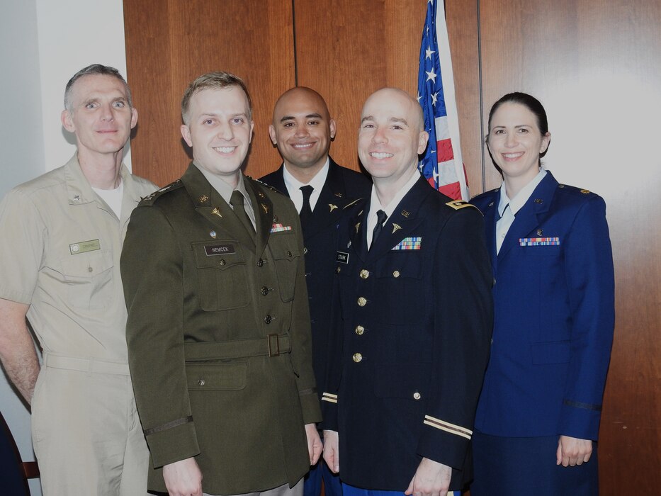 U.S. Navy Cmdr. (Dr.) Wesley Campbell (left), director of education, training and research at Walter Reed, congratulates presenters for the Bailey K. Ashford research award (beginning second from left) Army Capt. (Dr.) Steven Nemcek, Army Capt. (Dr.) Robert Sgrignoli, Army Maj. (Dr.) Christopher Stark, and Air Force Maj. (Dr.) Karin Brockman following their presentations on May 6 at Walter Reed.