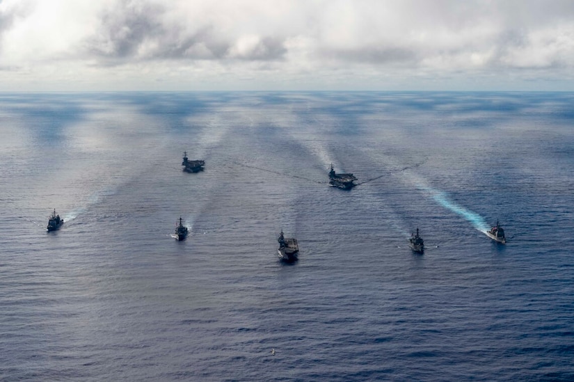 U.S. and foreign navy ships sail in open waters.