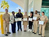 GUANTANAMO BAY, Cuba (May 10, 2024) - The Multi-Service Ward nursing staff at U.S. Naval Hospital Guantanamo Bay, won the DAISY Team Award, May 10. The award was established by The DAISY Foundation to recognize the extraordinary work of nurses worldwide. From left to right: Cdr. Christopher Weiss (presenting), Lt. Cmdr. Erin Williams, Lt. Cmdr. Joshua Womack, Lt. j.g. Kaitlin Kowker, Lt. j.g. Vanessa Bernales, Ens. Esther Ulysse and Lt. j.g. Katherine Rubio Jackson.