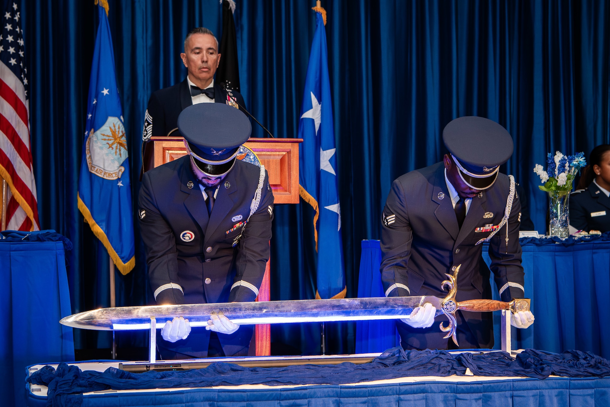 U.S. Air Force Academy Honor Guard members lift the sword used for the Order of the Sword ceremony in the Arnold Hall Ballroom May 11, 2024. The Order of the Sword is an honor awarded by noncommissioned officers to recognize individuals they hold in high regard and for their contributions to the enlisted corps.