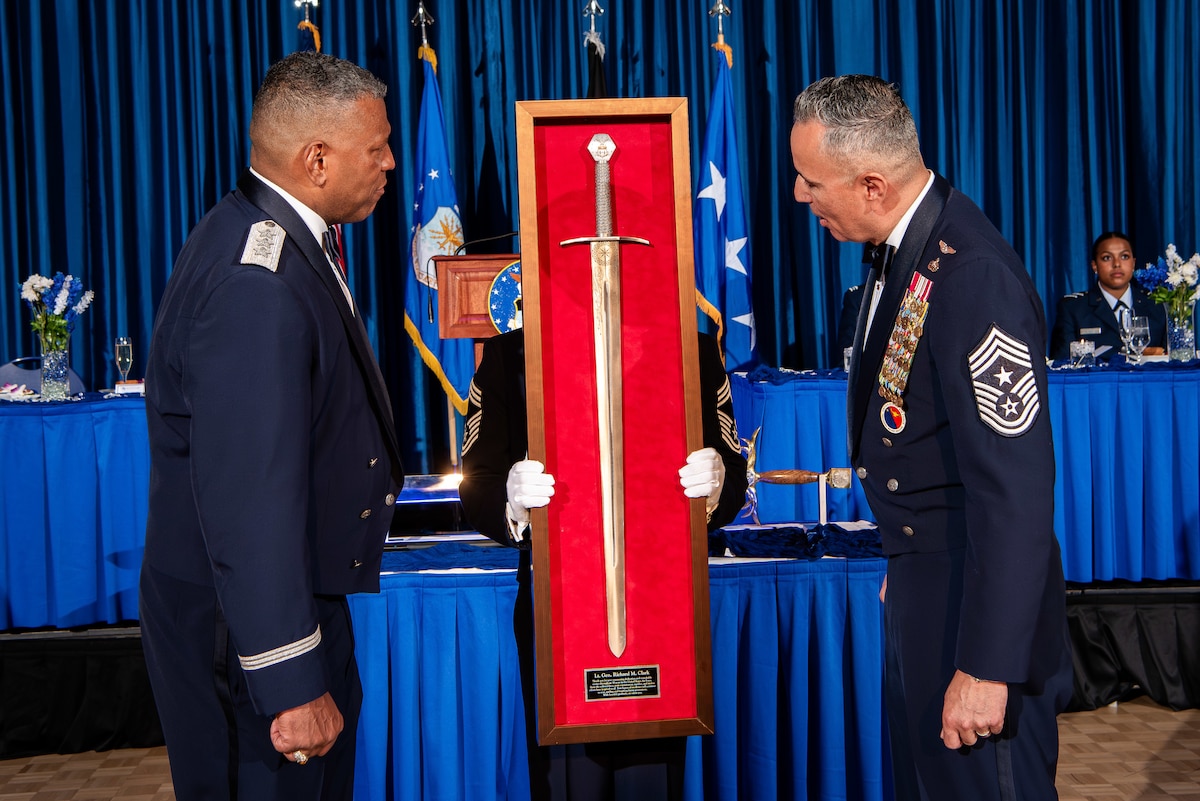 Chief Master Sgt. Heriberto G. Diaz Jr., right, command chief master sergeant, presents the Order of the Sword to Lt. Gen. Richard M. Clark, left, superintendent, at the U.S. Air Force Academy, May 11, 2024.
