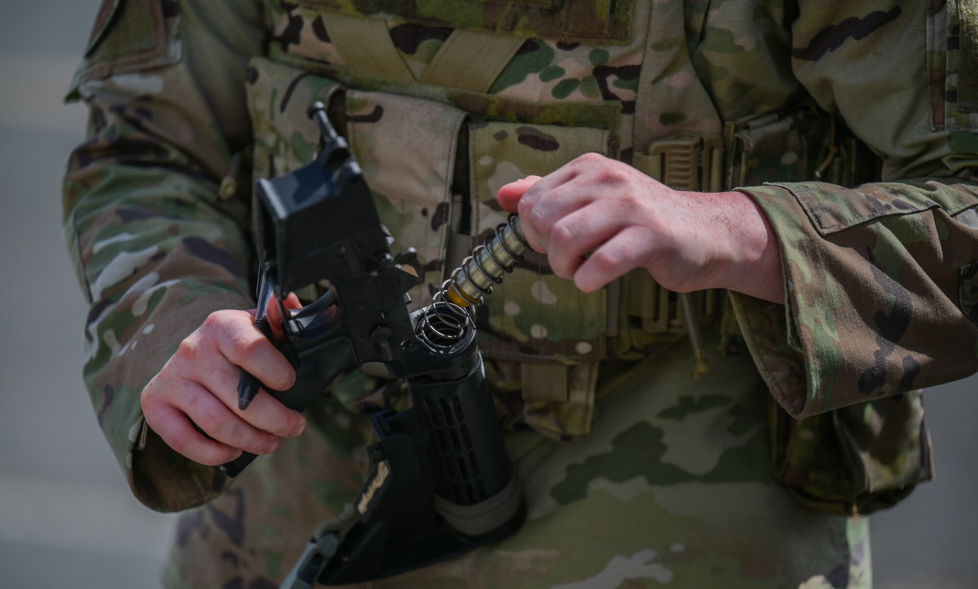 Airman dismantles rifle.