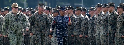 240513-N-JS660-1242 BANDAR LAMPUNG, Indonesia (May 13, 2024) From left to right, U.S. Navy Capt. Tate Robinson, commodore of Amphibious Squadron Five, U.S. Marine Corps Col. Sean Dynan, commanding officer, 15th Marine Expeditionary Unit, and Indonesian Navy (TNI-AL) Rear Admiral Yoos Suryono Hadi, commander, Fleet Command I, troop the line during the opening ceremony of Combined Afloat Readiness and Training (CARAT) Indonesia 2024, on Battalion Infantry-9 Marine Division in Lampung, Indonesia, May 13, 2024. This year marks the 30th iteration of CARAT, a multinational exercise series designed to enhance U.S. and partner navies' abilities to operate together in response to traditional and non-traditional maritime security challenges in the Indo-Pacific region. (U.S. Navy photo by Mass Communication Specialist 2nd Class Evan Diaz)