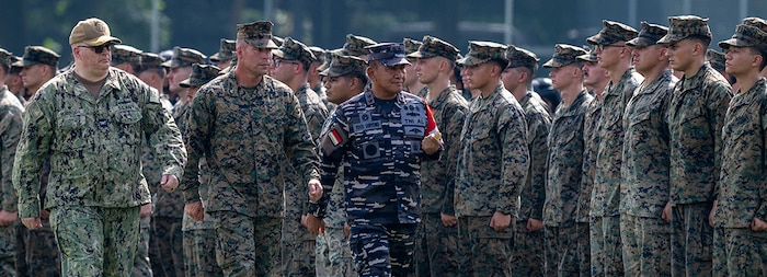 240513-N-JS660-1242 BANDAR LAMPUNG, Indonesia (May 13, 2024) From left to right, U.S. Navy Capt. Tate Robinson, commodore of Amphibious Squadron Five, U.S. Marine Corps Col. Sean Dynan, commanding officer, 15th Marine Expeditionary Unit, and Indonesian Navy (TNI-AL) Rear Admiral Yoos Suryono Hadi, commander, Fleet Command I, troop the line during the opening ceremony of Combined Afloat Readiness and Training (CARAT) Indonesia 2024, on Battalion Infantry-9 Marine Division in Lampung, Indonesia, May 13, 2024. This year marks the 30th iteration of CARAT, a multinational exercise series designed to enhance U.S. and partner navies' abilities to operate together in response to traditional and non-traditional maritime security challenges in the Indo-Pacific region. (U.S. Navy photo by Mass Communication Specialist 2nd Class Evan Diaz)