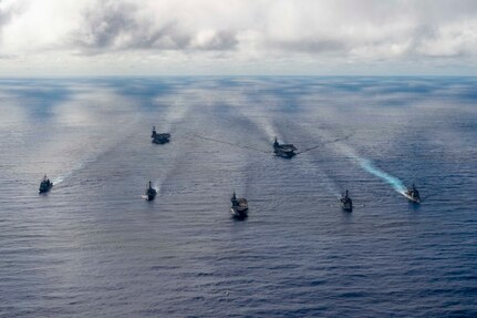 U.S. and foreign navy ships sail in open waters.