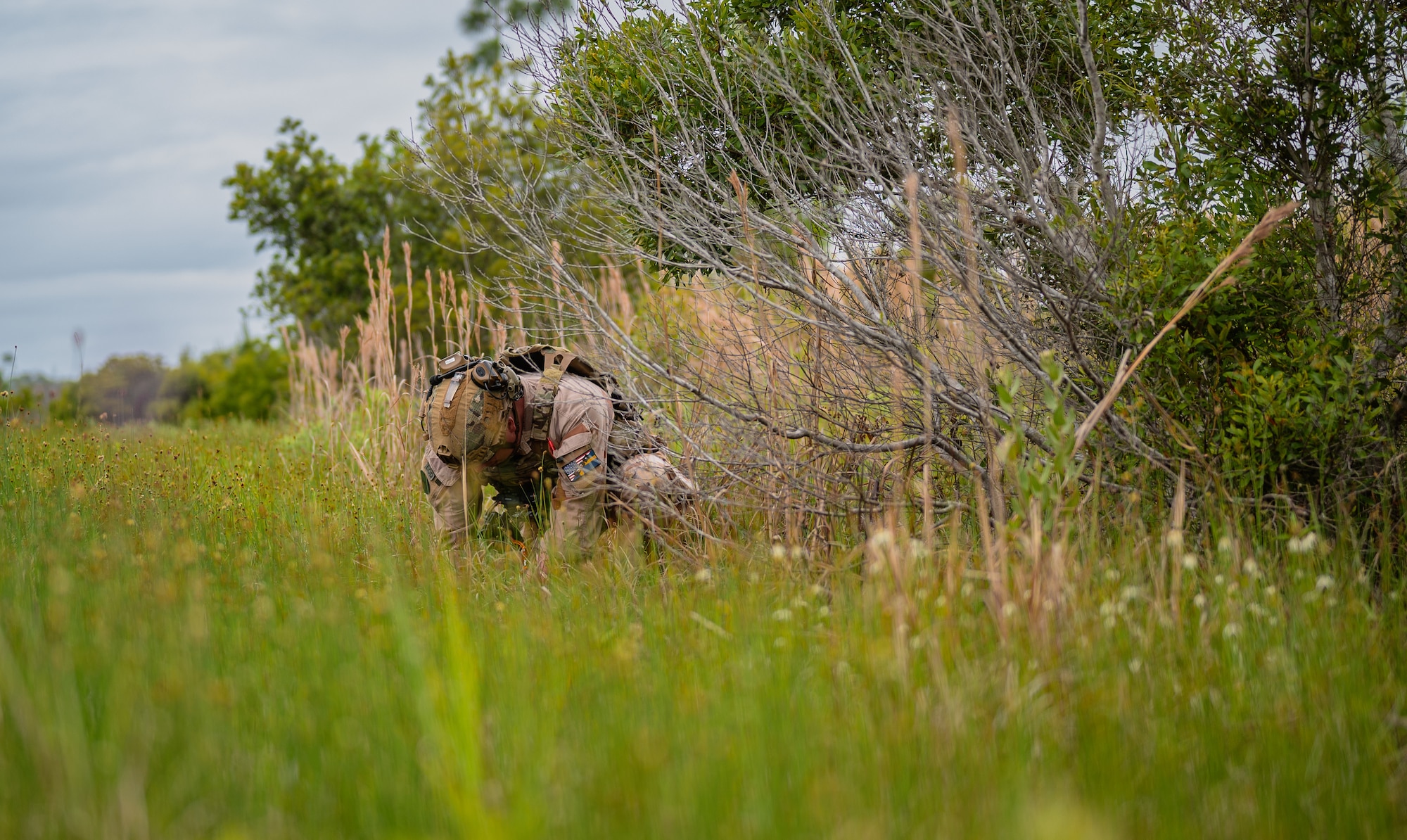 military man crouched in field