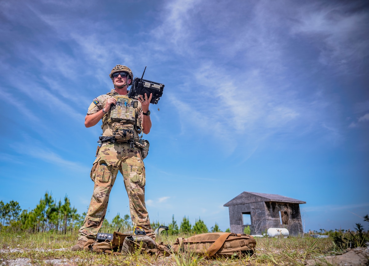 military man stands with remote device