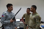 U.S. Air Force Staff Sgt. Quincy Brooks, 644th Combat Communication Squadron client systems technician, briefs Philippine Air Force 1st Lt. John Mangaoang, assistant director for command and control capability for the office of the assistant chief of Air Staff, about the Harris PRC-152A line of sight radio capabilities during Cope Thunder 24-1 at Basa Air Base, Philippines, Apr. 12, 2024. Cope Thunder 24-1 enables the U.S. and the Philippines to integrate capabilities and technologies to enhance interoperability at all levels. (U.S. Air Force photo by Master Sgt. Darnell T. Cannady)