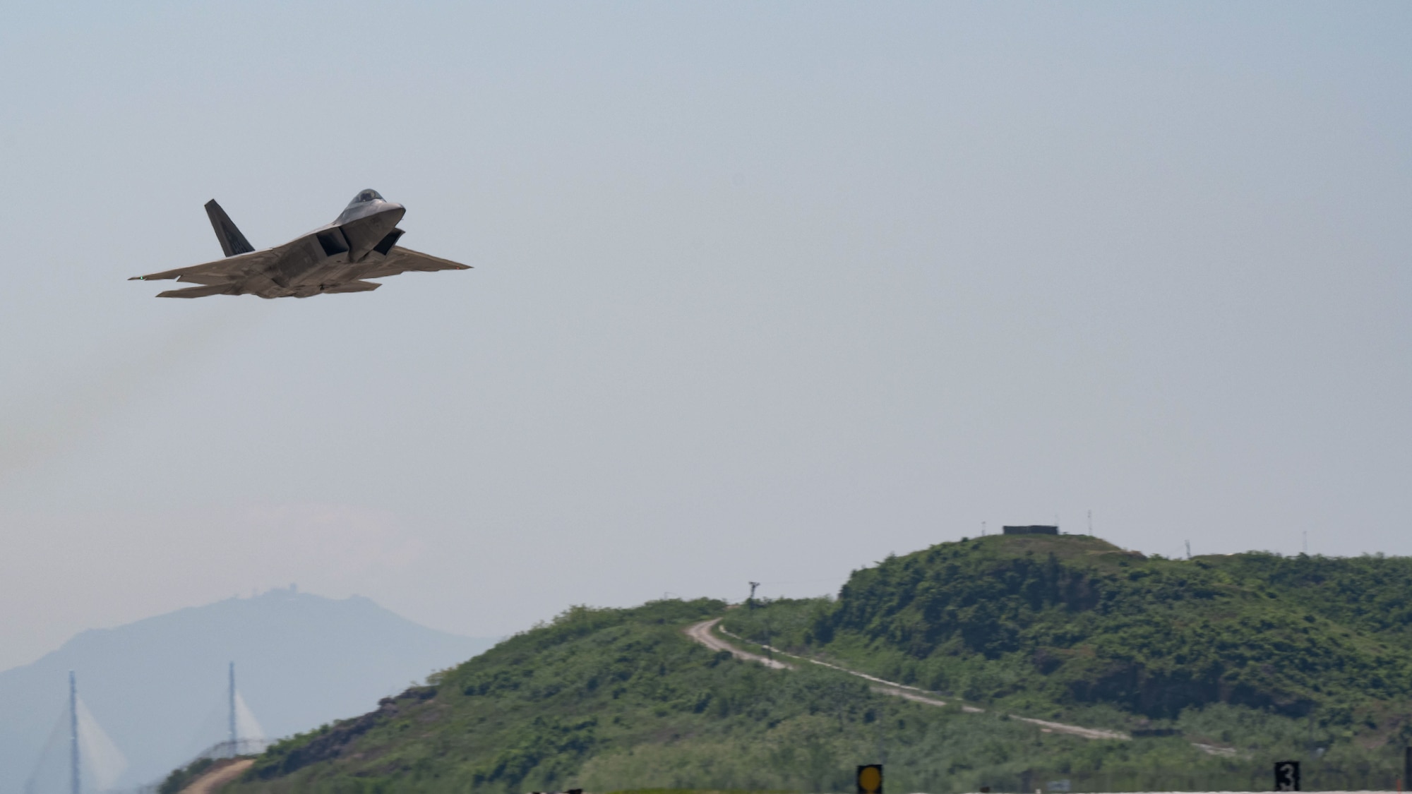An F-22 Raptor, assigned to Joint Base Pearl Harbor-Hickam, flies over Kunsan Air Base.