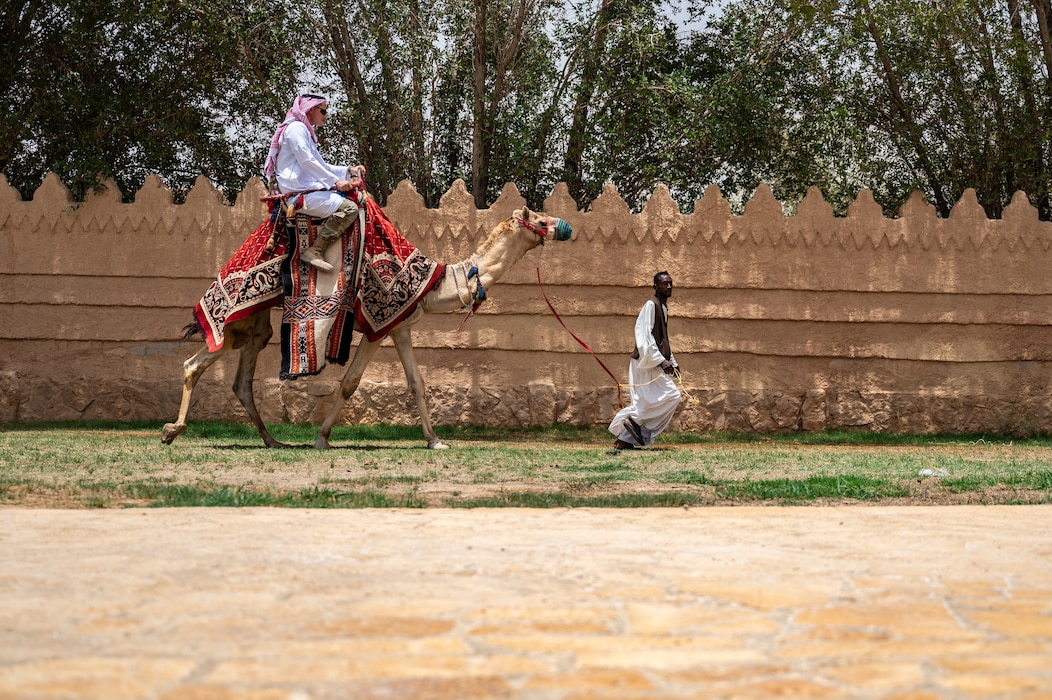 A U.S. Air Force pavement and equipment technician assigned to the 378th Expeditionary Civil Engineer Squadron rides a camel during a Saudi Arabian Culture Day at an undisclosed location within the U.S. Central Command area of responsibility, May 11, 2024. Integrating with our partners strengthens relationships and trust, which can be particularly important in times of crisis. (U.S. Air Force photo)