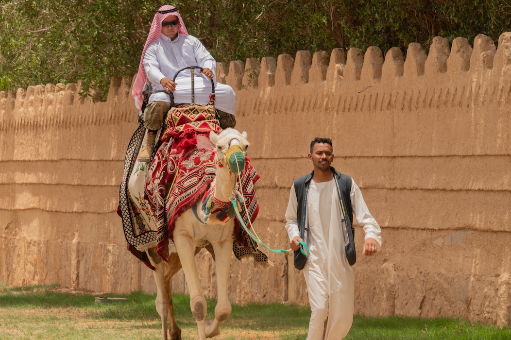 A U.S. Marine assigned to the 2nd Marine Logistics Group rides a camel during a Saudi Arabian Culture Day during Exercise Native Fury 24 at an undisclosed location within the U.S. Central Command area of responsibility, May 13, 2024. The U.S. remains committed to improving partner relationships to foster a more interoperable force. (U.S. Air Force photo)