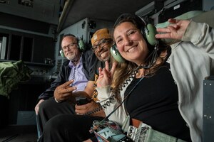 Teachers pose for a photo inside the cockpit of a C-130J Super Hercules.