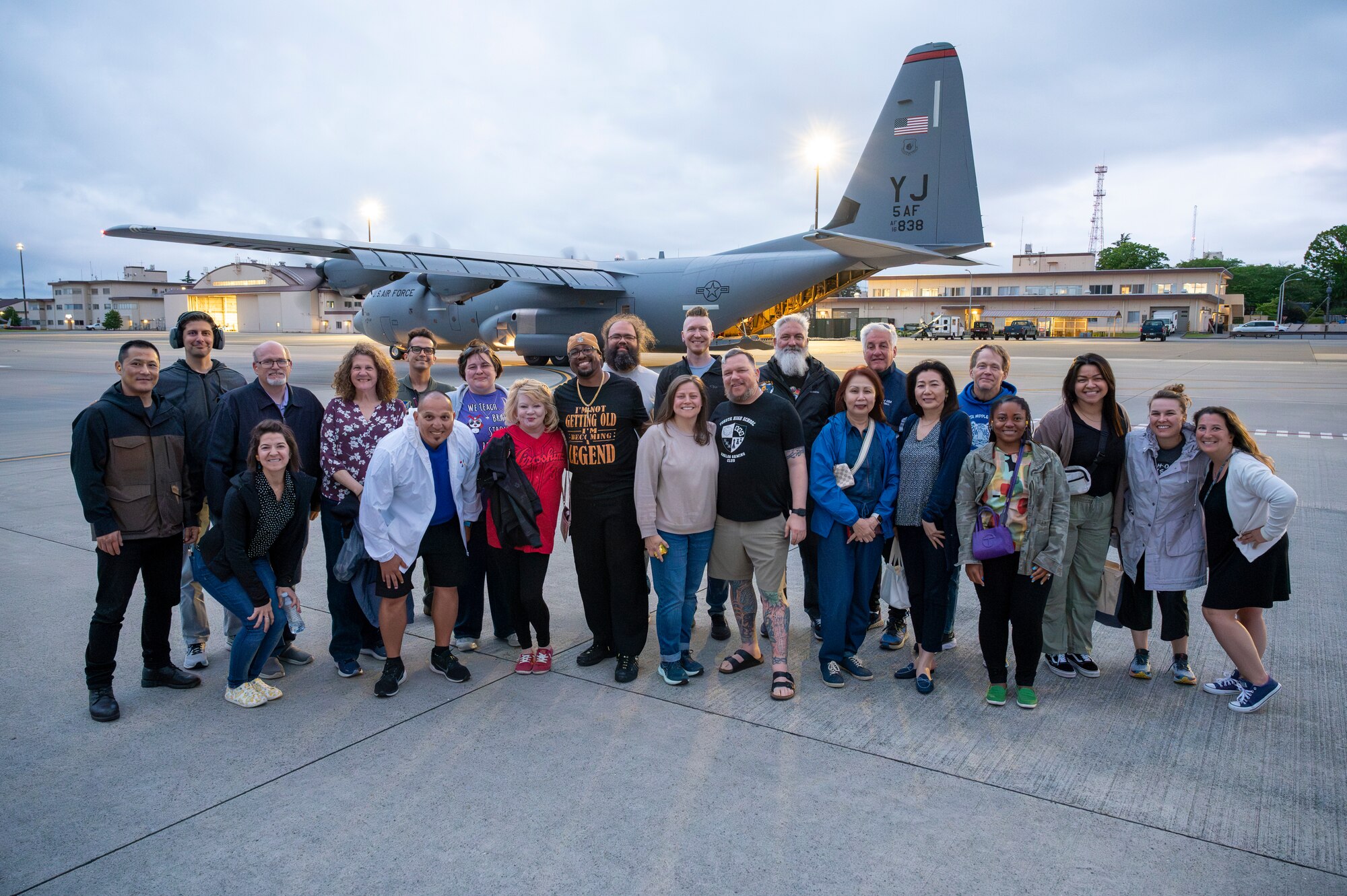 Teachers pose for a photo in front of a C-130J Super Hercules.