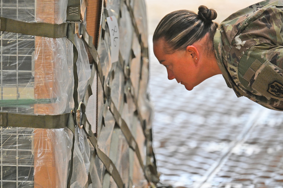 Soldier looks at shipping label.