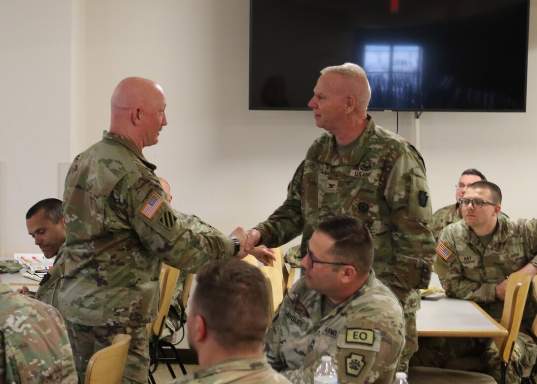 Col. Christopher Costello, Commander of the 56th Stryker Brigade Combat Team, 28th Infantry Division, Pennsylvania Army National Guard presents his coin to Col. Stuart James, the First Army Senior Regular Army Advisor to the Pennsylvania National Guard. Col James instructed the Independence Brigade on Engagement-Area Development.