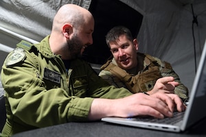 Royal Canadian Air Force Capt. Esteban Simard, 2 Wing air operations officer, has a conversation with U.S. Air Force Lt. Col. Andrew Nation, 621st Contingency Response Squadron commander during Exercise Storm Flag in Alexandria, Louisiana, May 8, 2024.