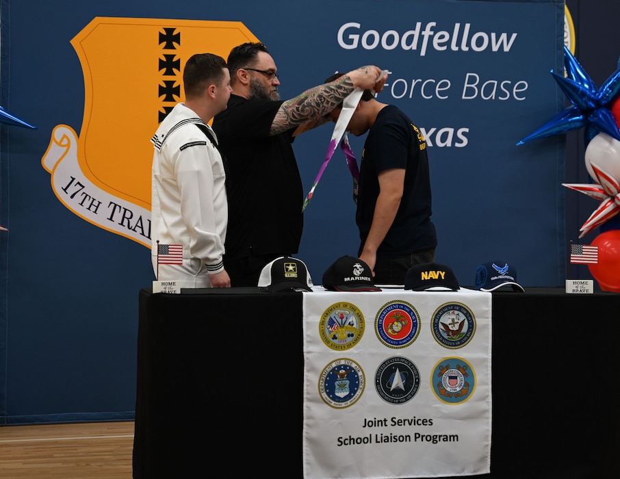 Luis Martinez, San Angelo Disabled American Veteran commander, places a graduation stole on a San Angelo Independent School District senior during the second annual Goodfellow Air Force Base Armed Forces Commitment Celebration at the Mathis Fitness Center, Goodfellow Air Force Base, Texas, May 10, 2024. A total of 23 seniors from San Angelo Independent School District attended to celebrate their commitment to military service. (U.S. Air Force photo by Airman First Class Evelyn J. D’Errico)