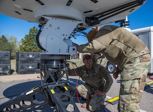 Two Guardians setting up equipment and antennas during a field training exercise.