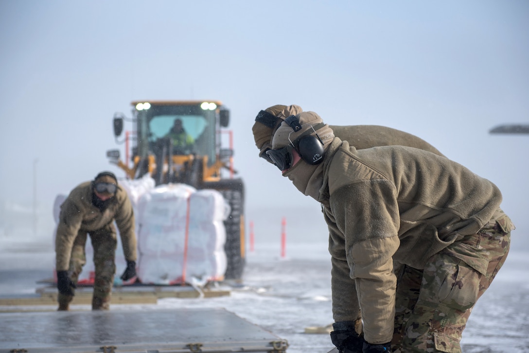 Airmen from the Kentucky Air National Guard’s 123rd Logistics Readiness Squadron secure cargo pallets after offloading construction supplies from a Kentucky C-130J Super Hercules aircraft under blizzard conditions in Deadhorse, Alaska, on April 26, 2024. The materials, which will be used to build homes for civilians, were airlifted as part of Innovative Readiness Training, a Defense Department program that provides service members with real-world deployment experience while offering lasting benefits to civilian populations. (U.S. Air National Guard photo by Airman 1st Class Annaliese Billings)