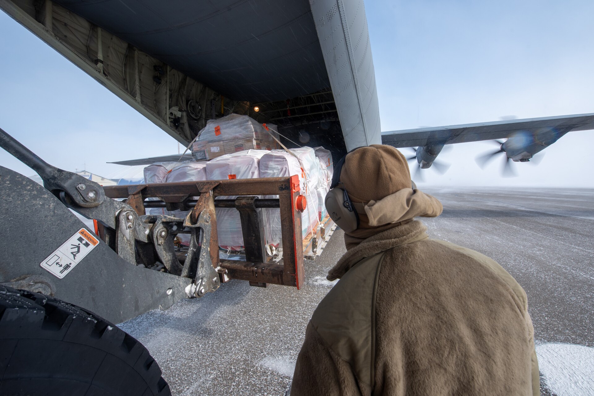 Airmen from the Kentucky Air National Guard’s 123rd Airlift Wing unload cargo from a Kentucky C-130J Super Hercules aircraft under blizzard conditions in Deadhorse, Alaska, on April 26, 2024. Airmen from the squadron also palletized the cargo, which consists of construction materials to build homes for civilians as part of Innovative Readiness Training, a Defense Department program that provides service members with real-world deployment experience while offering lasting benefits to civilian populations. (U.S. Air National Guard photo by Phil Speck)