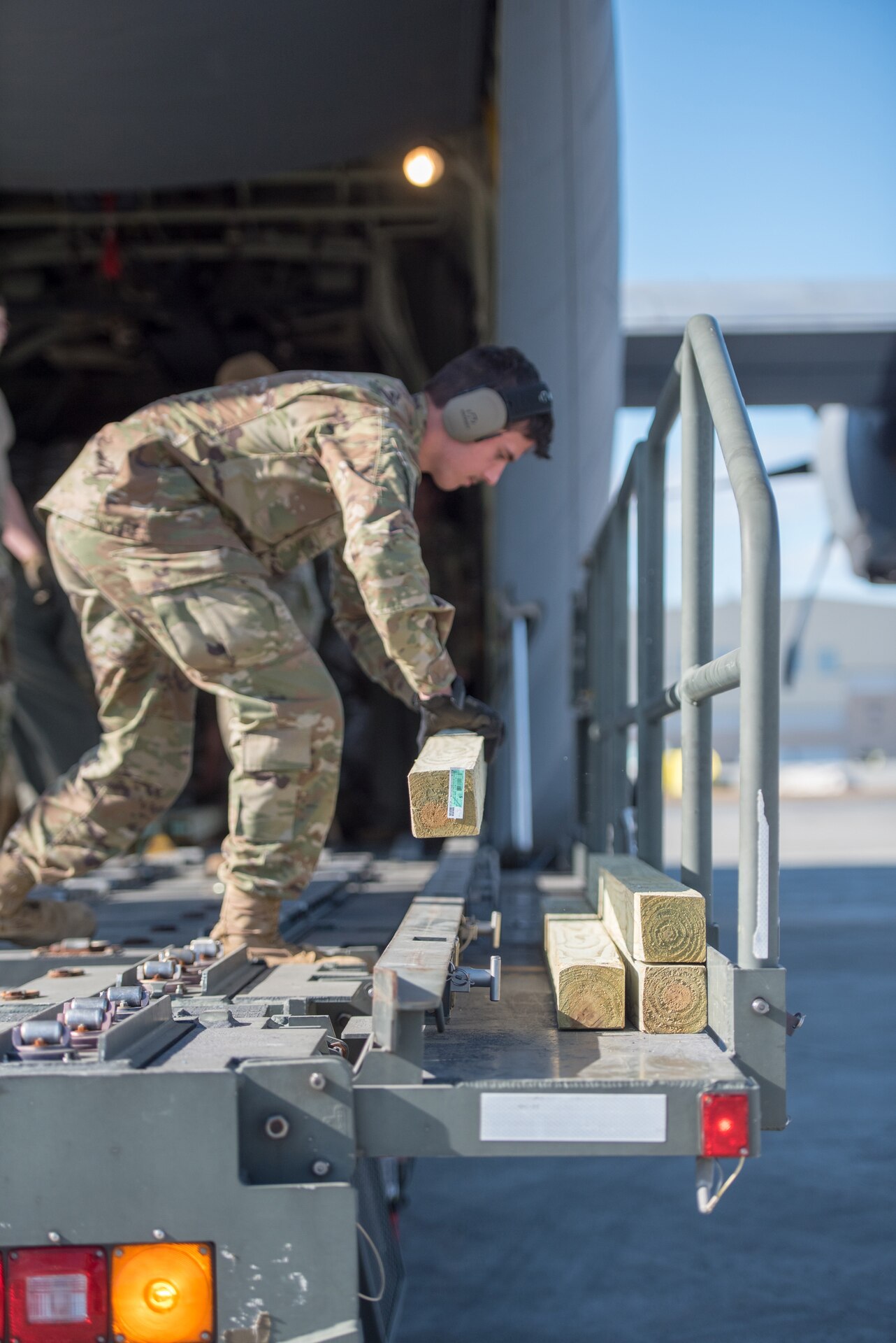 Airman First Class Elijah Stansberry, an aerial porter from the Kentucky Air National Guard’s 123rd Logistics Readiness Squadron, prepares lumber for airlift aboard a Kentucky C-130J Super Hercules aircraft at Joint Base Elmendorf-Richardson, Alaska, April 24, 2024. The lumber and other construction materials will be used to build homes for civilians on Alaska’s North Slope as part of Innovative Readiness Training, a Defense Department program that provides service members with real-world deployment experience while offering lasting benefits to civilian populations. (U.S. Air National Guard photo by Airman 1st Class Annaliese Billings)