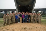 Honorary Commanders for the 502nd Air Base Wing and servicemembers from the 59th Training Support Squadron pose in front of a C-130 transport aircraft.