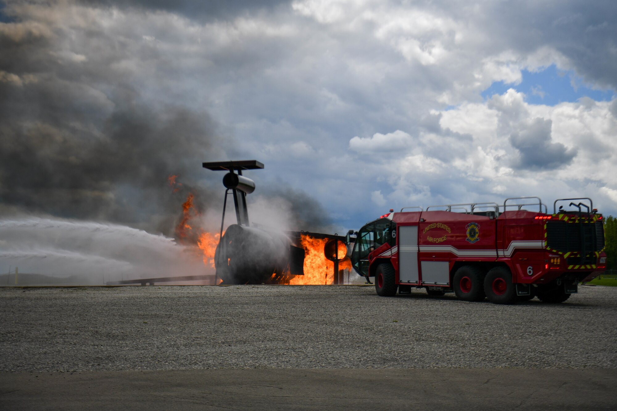 Fire engine 6 sprays water on a mock aircraft crash at the firefighter training area as part of a demonstration during a local educator installation tour at Youngstown Air Reserve Station, Ohio, May 10, 2024.