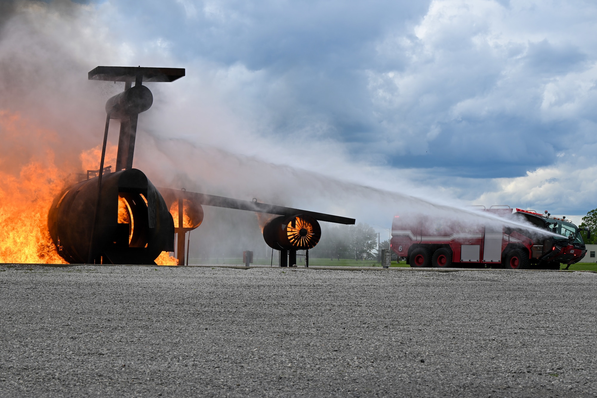 Members of Youngstown Air Reserve Station’s fire department spray water on a simulated aircraft fire at the firefighter training area here, May 10, 2024, during a demonstration for local educators.