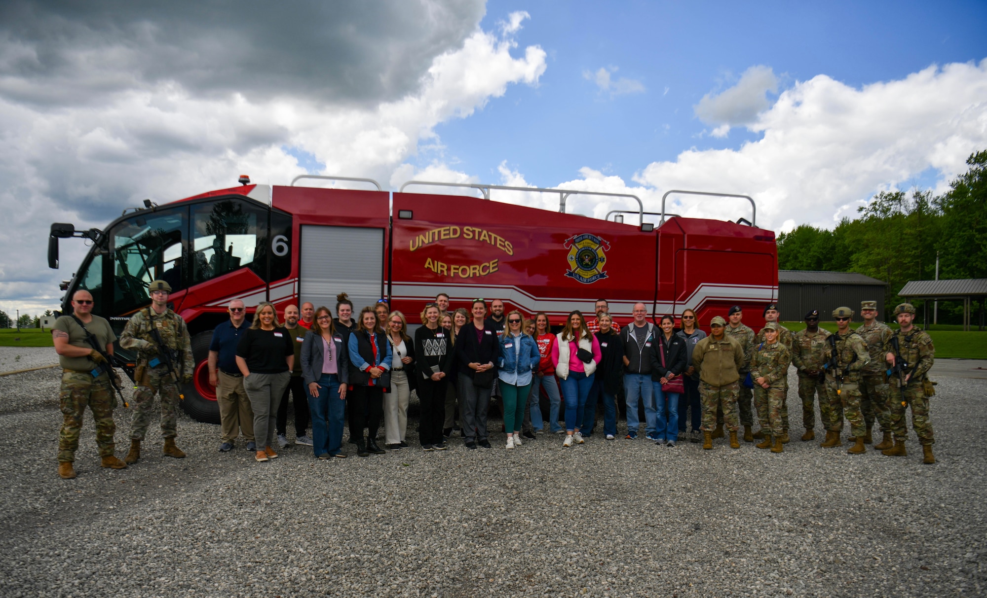 Reserve Citizen Airmen assigned to the 910th Airlift Wing and local educators from the Youngstown Air Reserve Station recruitment area pose for a group photo in front of fire engine 6 after a security forces and firefighter training demonstration at Youngstown Air Reserve Station, Ohio, May 10, 2024.