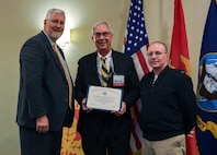 Vice Adm. David Lewis, USN (Ret.) (left) and Chief Engineer and Deputy Commander for Ship Design, Integration and Naval Engineering, SEA-05, Naval Sea Systems Command Rear Adm. Jason Lloyd (right) present the Harold E. Saunders (Lifetime Achievement) Award to Dr. E. Michael Golda (middle) for his dedication and lifetime contributions to the U.S. Navy. The event took place during the 2024 American Society of Naval Engineers (ASNE) Advanced Machinery Technology Symposium (AMTS), held at the Delta Hotel Philadelphia Airport in Philadelphia on May 1-2, 2024. (U.S. Navy Photo by Jay Butterbaugh/Released)