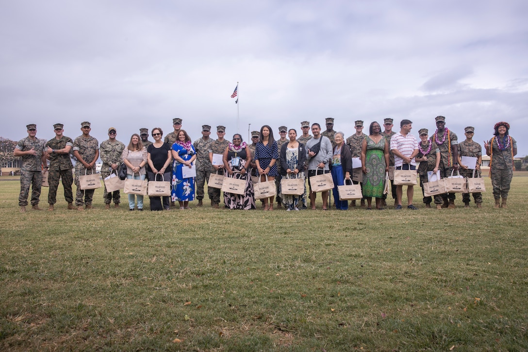 U.S. service members and civilians pose for a group photo after a volunteer recognition ceremony at Marine Corps Base Hawaii, April 26, 2024. The ceremony recognized and honored individuals who demonstrated a sustained commitment to volunteer service over the course of the past year. (U.S. Marine Corps photo by Sgt. Julian Elliott-Drouin)