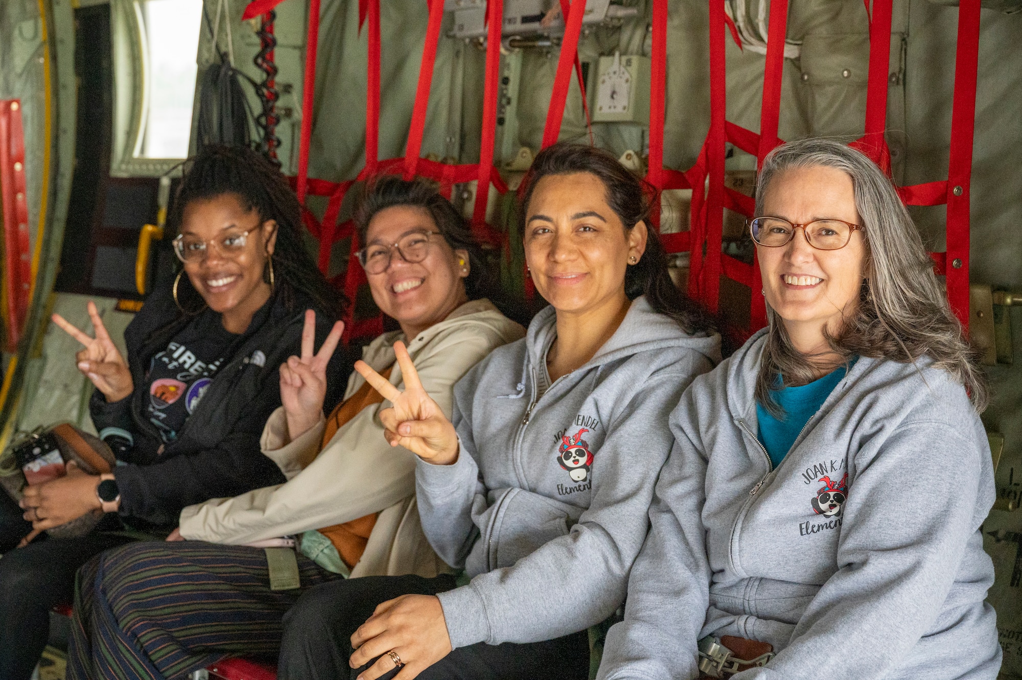 Teachers pose for a photo inside a C-130J Super Hercules.