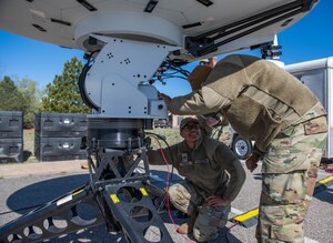 Two Guardians setting up equipment and antennas during a field training exercise.