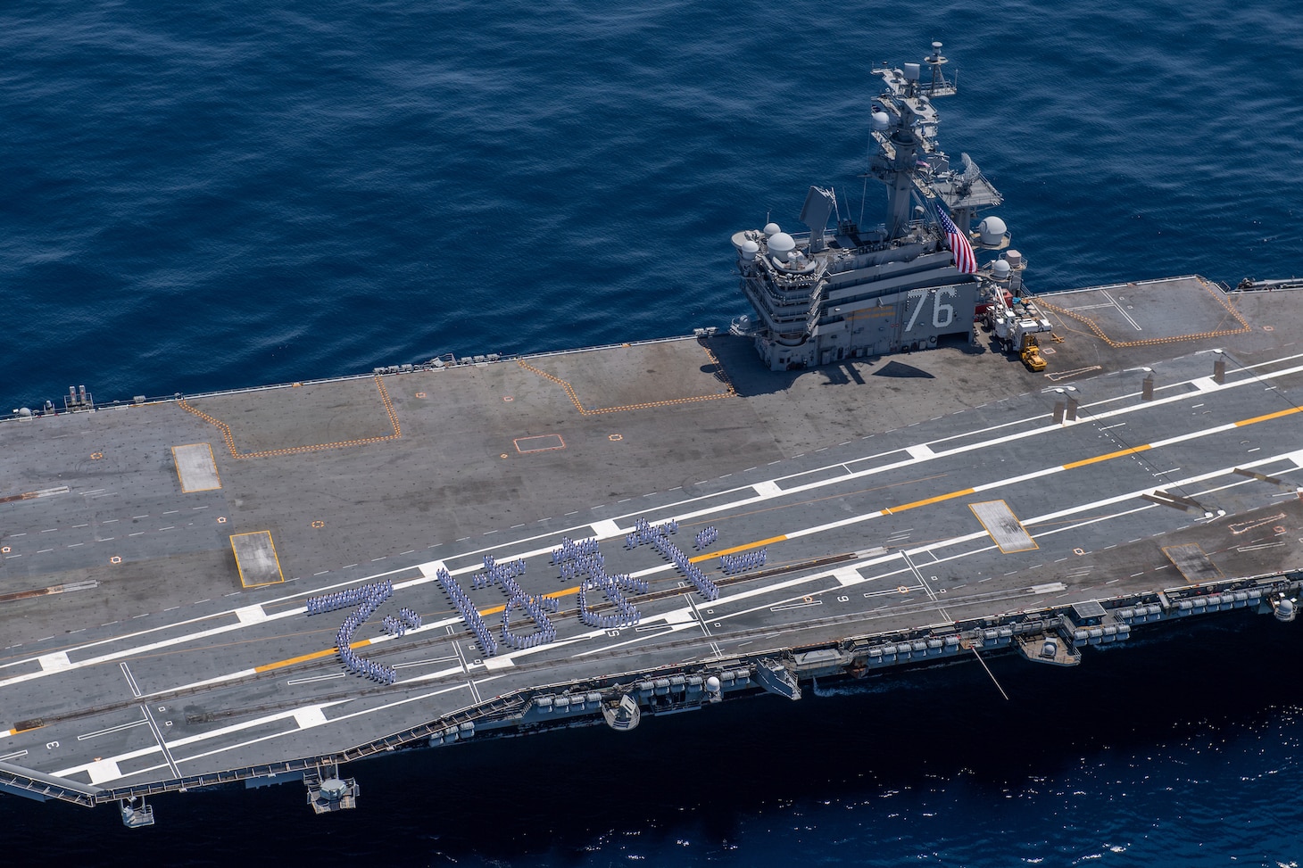 240510-N-AR554-1086 TOKYO INLET (May 10, 2024) Sailors stand in formation to form Japanese hiragana characters spelling “de wa mata,” which translates to “see you again”, on the flight deck of the U.S. Navy’s only forward-deployed aircraft carrier, USS Ronald Reagan (CVN 76), in the Tokyo Inlet, May 10. After nine years of service, Ronald Reagan is scheduled to depart Japan for the final time as the U.S. Navy’s Forward-Deployed Naval Forces Japan aircraft carrier. Ronald Reagan, the flagship of Carrier Strike Group 5, provides a combat-ready force that protects and defends the United States, and supports alliances, partnerships and collective maritime interests in the Indo-Pacific region. (U.S. Navy photo by Mass Communication Specialist 2nd Class Charlotte Dudenhoeffer).