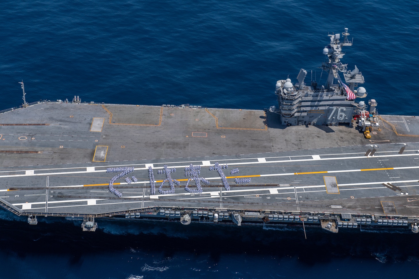 240510-N-AR554-1093 TOKYO INLET (May 10, 2024) Sailors stand in formation to form Japanese hiragana characters spelling “dewa mata,” which translates to “see you again,” on the flight deck of the U.S. Navy’s only forward-deployed aircraft carrier, USS Ronald Reagan (CVN 76), in the Tokyo Inlet, May 10. Ronald Reagan, the flagship of Carrier Strike Group 5, provides a combat-ready force that protects and defends the United States, and supports alliances, partnerships and collective maritime interests in the Indo-Pacific region. (U.S. Navy photo by Mass Communication Specialist 2nd Class Charlotte Dudenhoeffer).