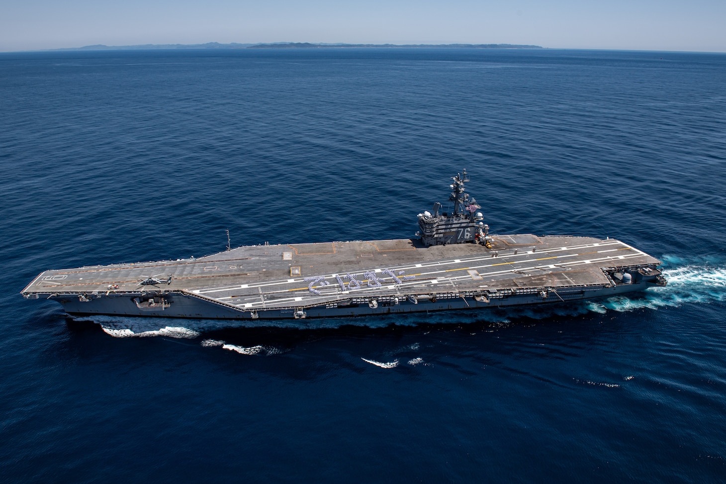 240510-N-AR554-1104 TOKYO INLET (May 10, 2024) Sailors stand in formation to form Japanese hiragana characters spelling “dewa mata,” which translates to “see you again,” on the flight deck of the U.S. Navy’s only forward-deployed aircraft carrier, USS Ronald Reagan (CVN 76), in the Tokyo Inlet, May 10. Ronald Reagan, the flagship of Carrier Strike Group 5, provides a combat-ready force that protects and defends the United States, and supports alliances, partnerships and collective maritime interests in the Indo-Pacific region. (U.S. Navy photo by Mass Communication Specialist 2nd Class Charlotte Dudenhoeffer).