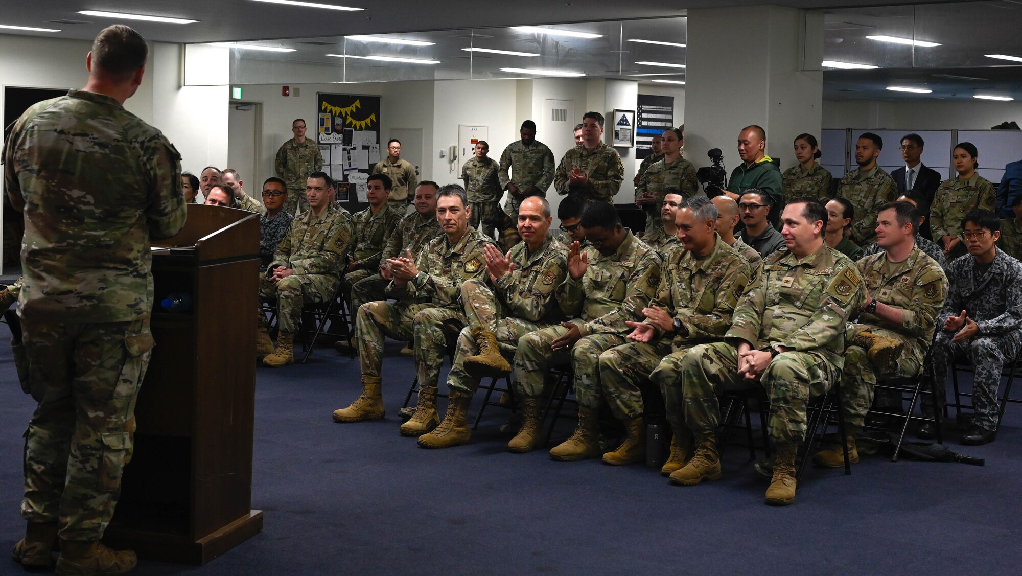 An Airman speaks in front of an audience.