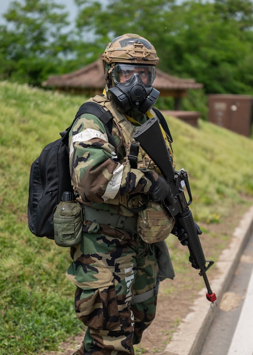 A U.S. Air Force Defender with the 51st Security Forces Squadron performs an exterior building sweep in a “bug out”  training event during Beverly Herd 24-1 at Osan Air Base, Republic of Korea. The training entailed members to evacuate their worksite, set up a temporary alternate location, and maintain the capability to maintain control of the central hub for wing-level situational awareness through all avenues. Routine training events like Beverly Herd are pivotal platforms for 51st Fighter Wing Airmen to refine their warfighting proficiencies through practical application, concurrently enhancing their ability to respond skillfully to contingencies. (U.S. Air Force photo by Staff Sgt. Aubree Owens)