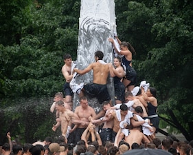 U.S. Naval Academy freshmen climb the Herndon Monument.