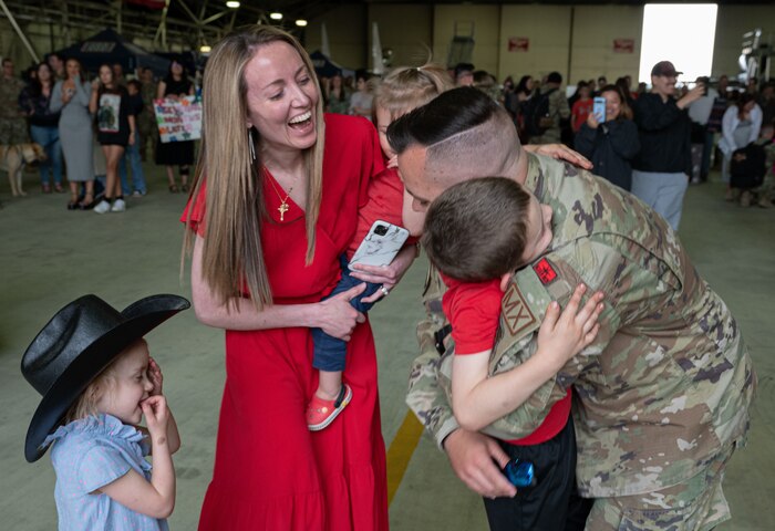 airman hugs child with family