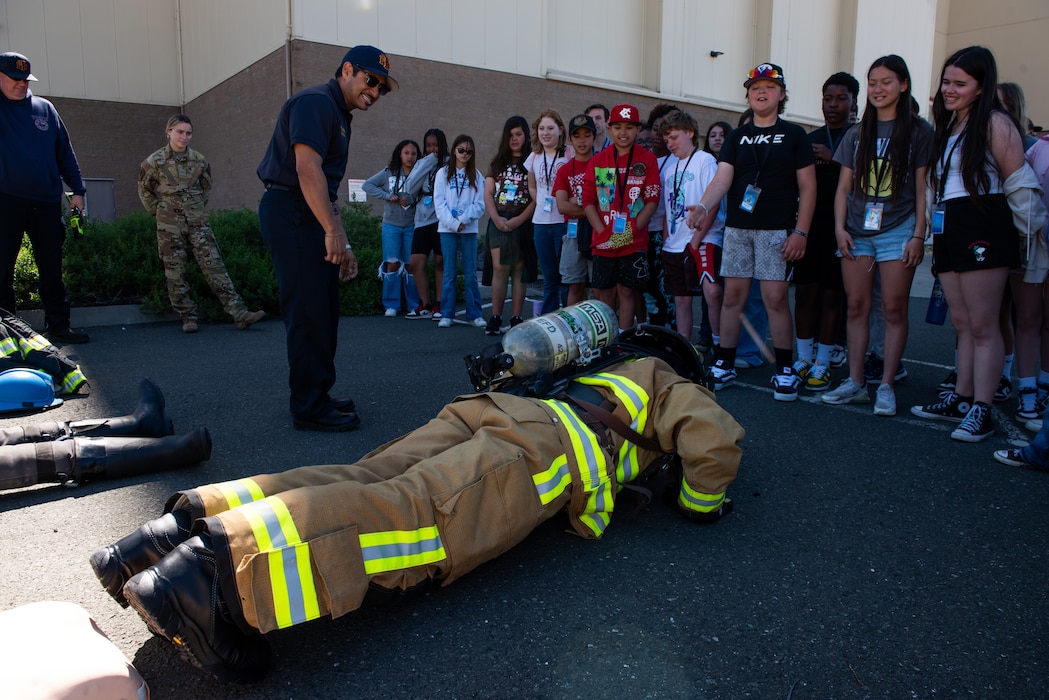 Fire fighter performs pushups in front of students
