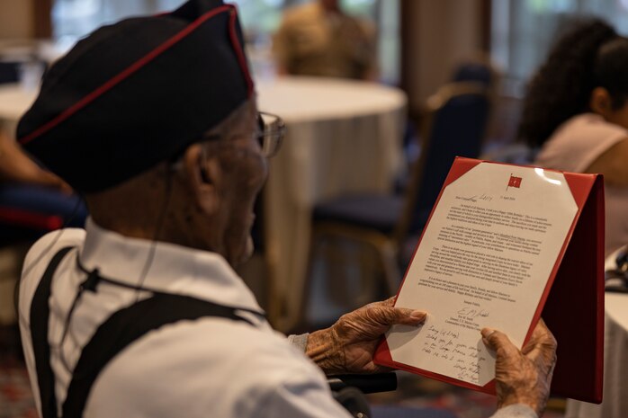Cpl. Lawrence Diggs, a Marine veteran of World War II, reads a personal letter from the Commandant of the Marine Corps, Gen. Eric Smith, during Diggs' one hundredth birthday celebration in Chicago, Ill., on May 4, 2024. Diggs, a native of Inverness, Miss., was drafted in 1943 and underwent recruit training at Montford Point, N.C. He served with the 7th Ammunition Company, 1st Marine Division, during the war in the Pacific Theater. After hostilities ceased and the war ended in 1946, Diggs returned to the United States, received a promotion to Corporal, and was subsequently discharged on May 11, 1946. (U.S. Marine Corps photo by Sgt. Dalton J. Payne)
