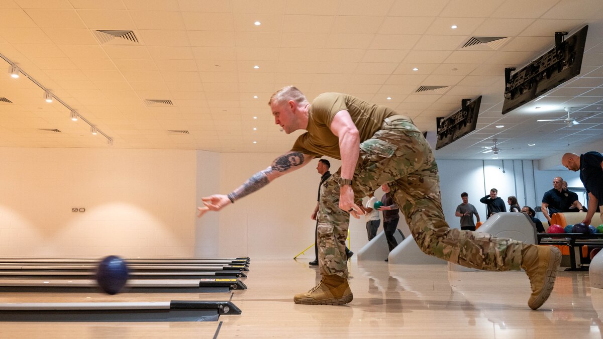 An Airman releases a bowling ball